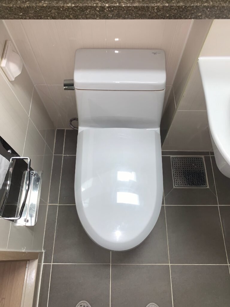 아파트 화장실에서 변기 위치가 벽면 쪽으로 치우친 상태